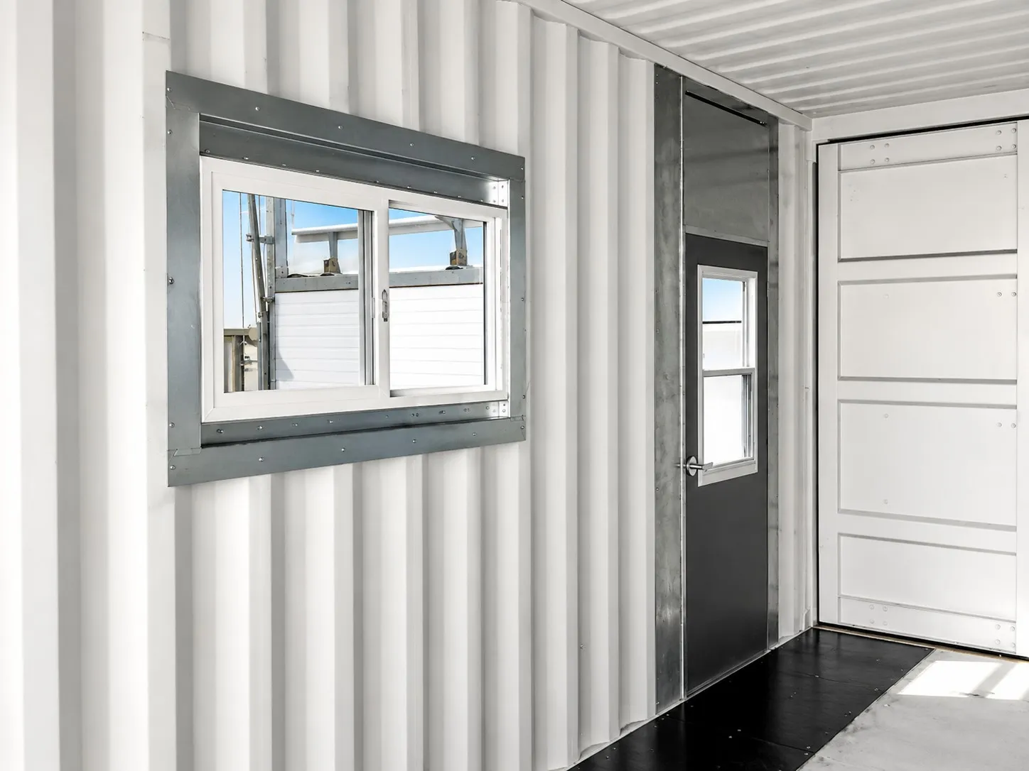 Container interior finished with an Insula window kit, secure access door and division wall